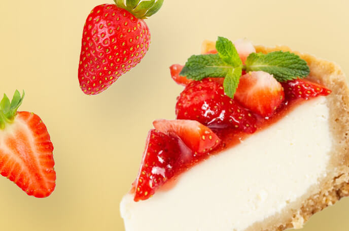cheesecake topped with strawberry preserve, fresh strawberry slices, and mint and two strawberries falling.