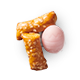 Two mini pretzel sticks beside a pink candy egg. Two mini pretzel sticks beside a pink candy egg.