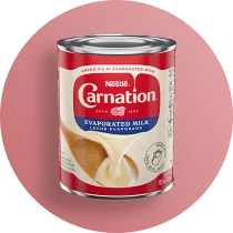 Fotografía: lata de leche evaporada Carnation de Nestlé sobre fondo rosa