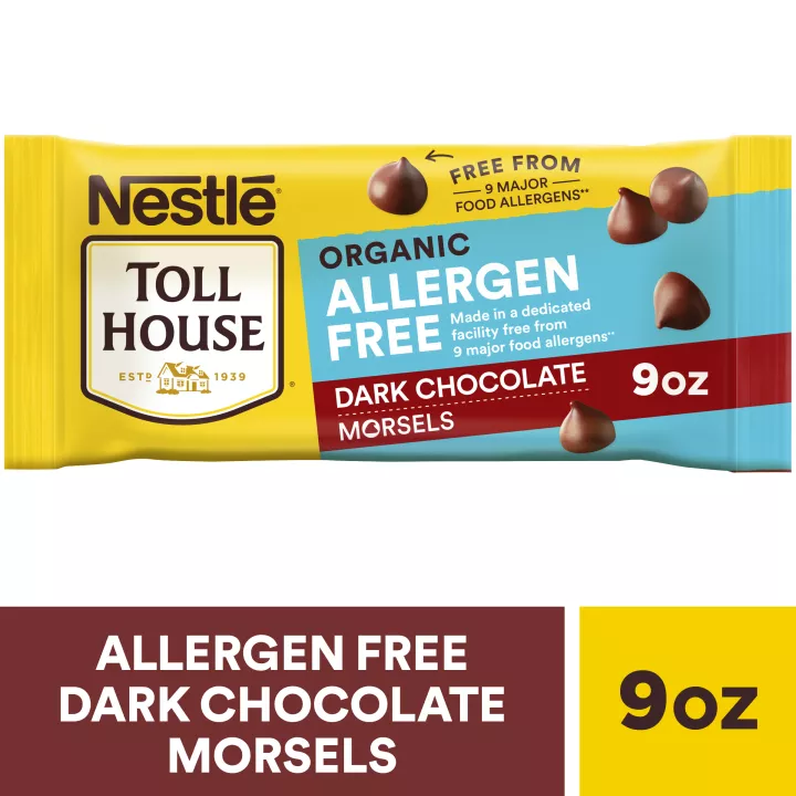 A package of allergen free dark chocolate morsels with a brown label beside a melty chocolate chip cookie.