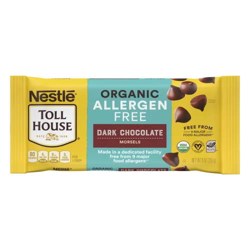 A package of allergen free dark chocolate morsels with a brown label beside a melty chocolate chip cookie.