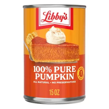 An orange and yellow can of 100% Pure Pumpkin with a slice of pumpkin pie on a silver serving spatula.