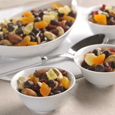 Photo of small white bowls filled with mixed nuts and dried apricots