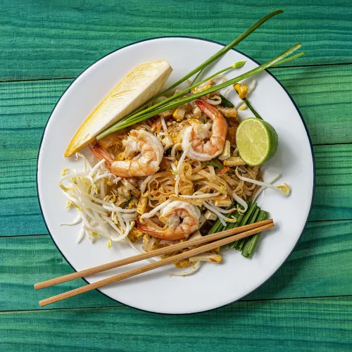Photo: plate of pad Thai with shrimp, bean sprouts, lime and lemon wedges, chives, chopsticks
