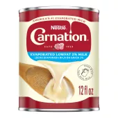 Fotografía frontal de una lata blanca, roja y azul de Leche Evaporada Reducida en Grasa al 2%. Tiene la marca Carnation y el logotipo de la flor, una tapa de botella de plástico azul oscuro, y una imagen de la leche evaporada vertiéndose en una espátula blanca.