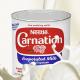 A can of Carnation Evaporated Milk with evaporated milk pouring, pooling, and splashing around the can.