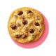 Overhead of a single chocolate chip cookie on a pink background